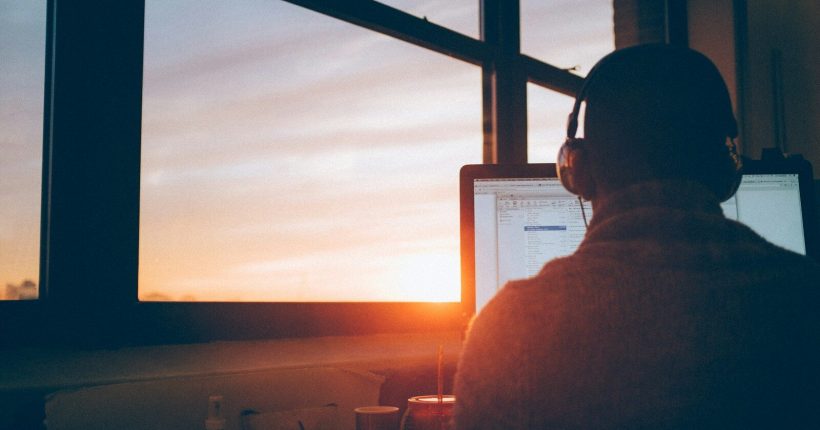 man sitting facing monitor
