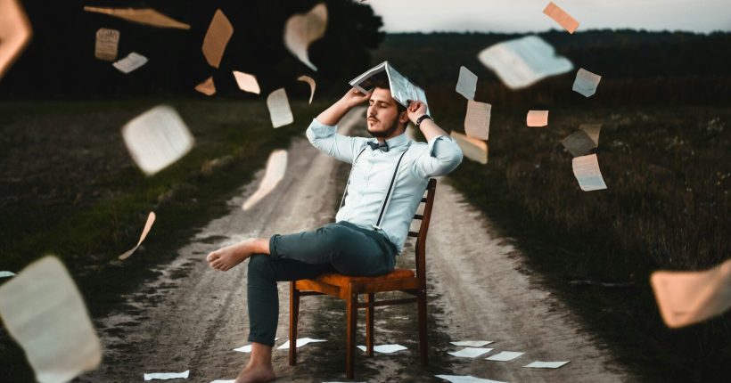 man sitting on chair with book