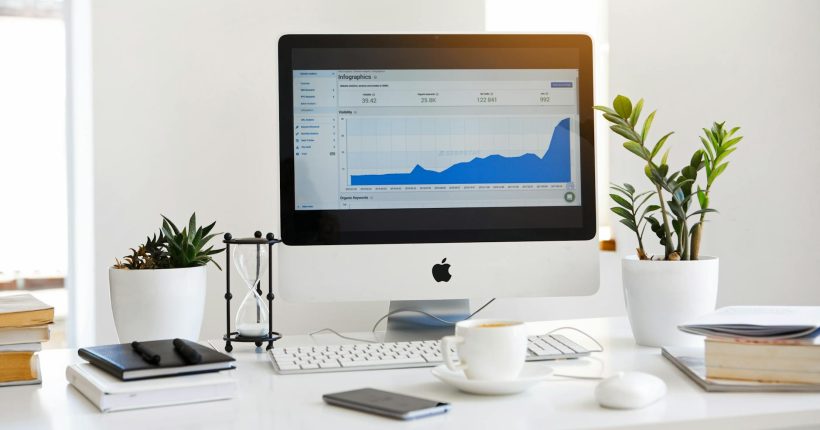 silver imac displaying line graph placed on desk