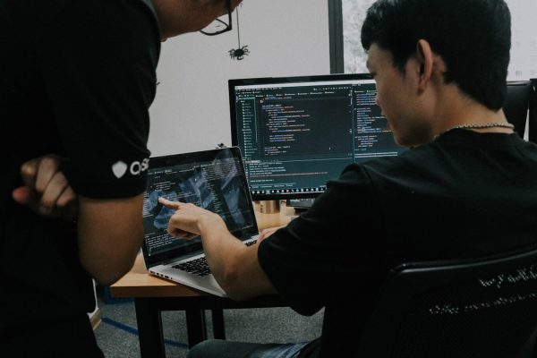 two men working on computers in an office