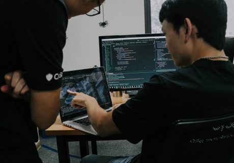 two men working on computers in an office
