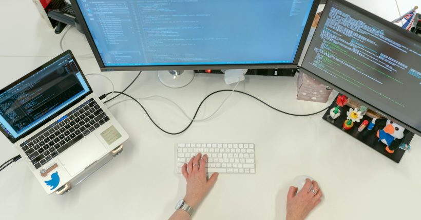 person using macbook pro on white table