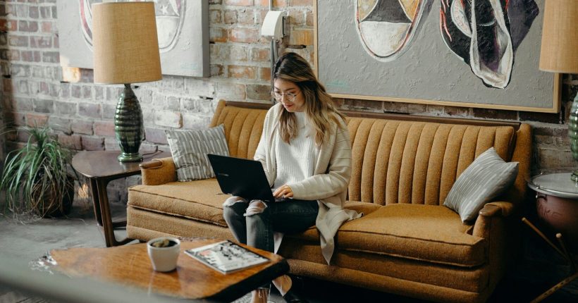 woman using laptop while sitting on chair