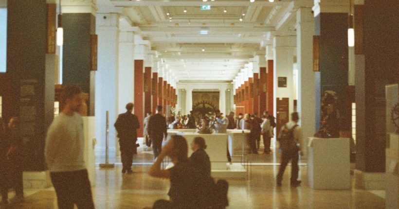 People walking through a grand museum hall.